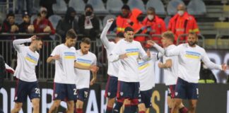 Cagliari, giocatori rossoblù in campo nel pre-partita con i colori dell’Ucraina